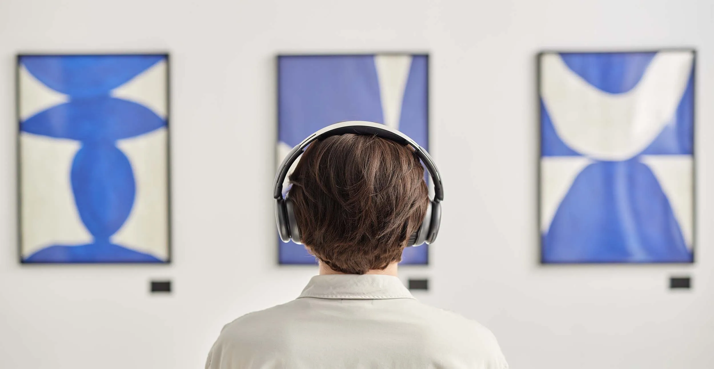 Person listening to audio of a piece of artwork.